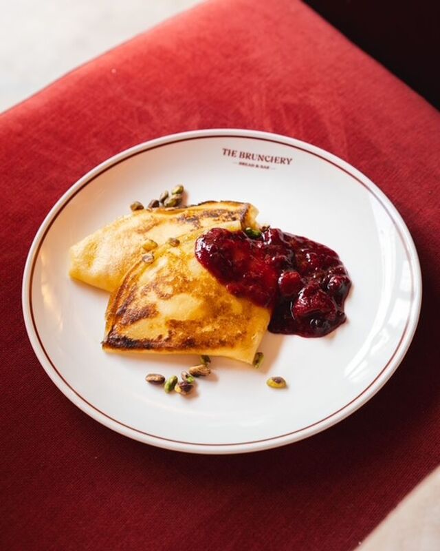 Naleśniki z konfiturą z owoców leśnych i pistacjami na firmowym talerzu